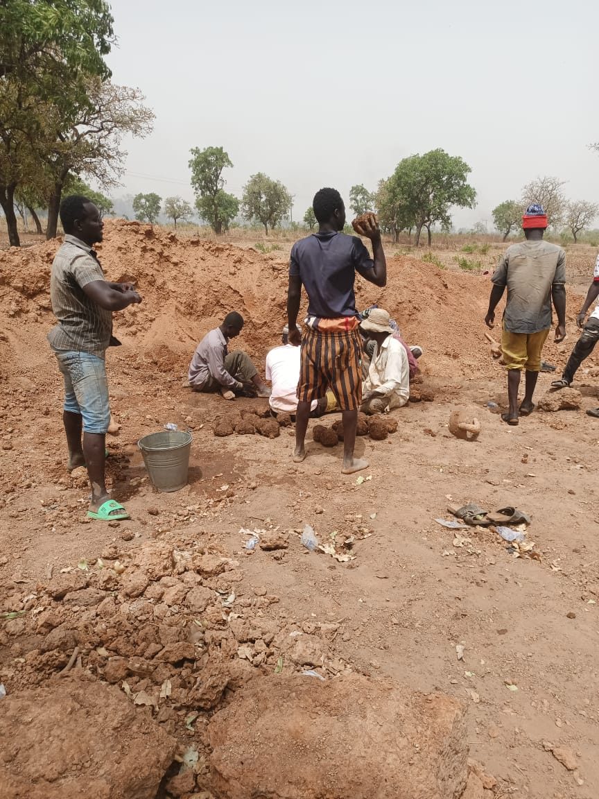 A team moulding mud bricks on open ground and laying them out to sun-dry