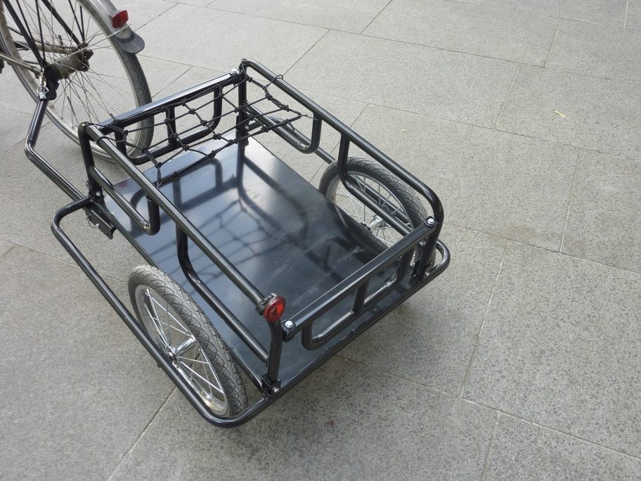 A single-axle bicycle cargo trailer with flat deck and hitch arm