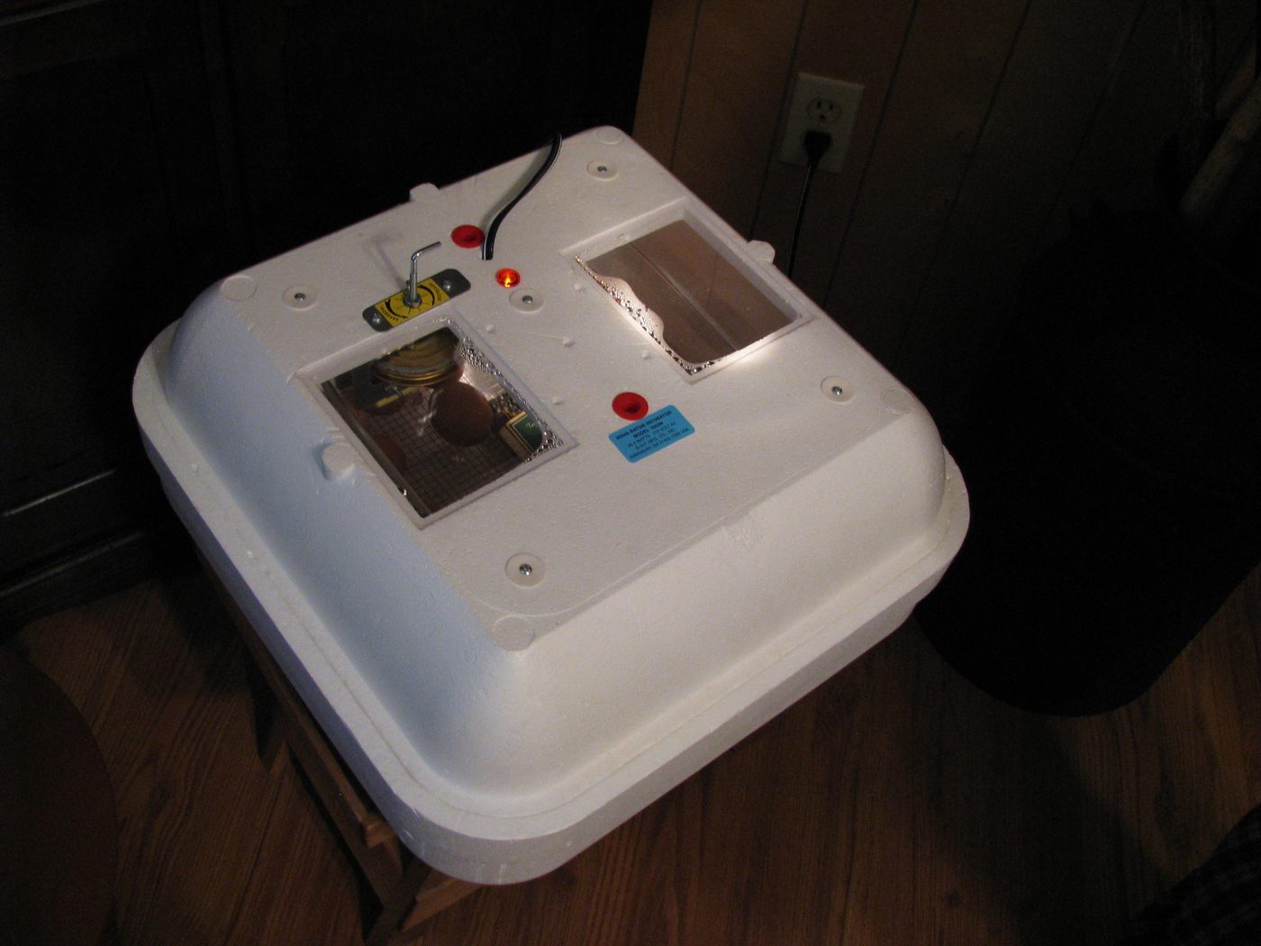 A small insulated box egg incubator with trays of eggs
