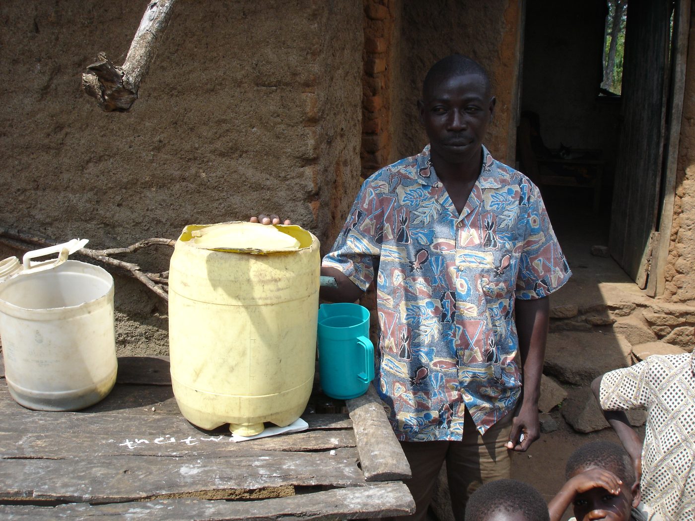 A builder standing beside the biosand water filter he constructed at his home near Raranya, Tanzania