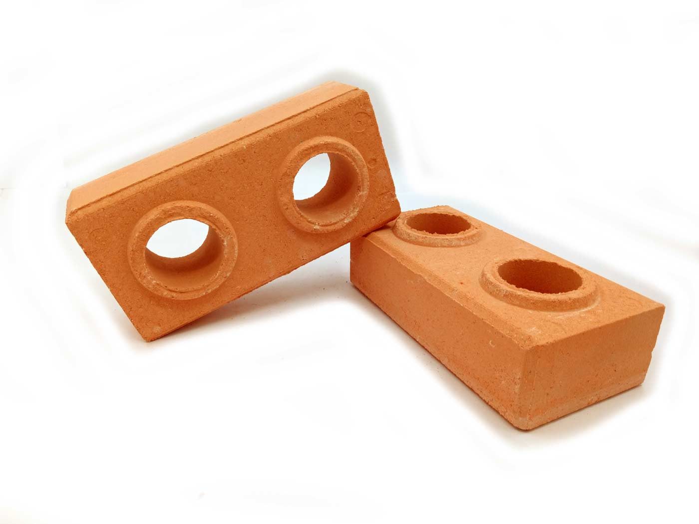 Interlocking compressed earth blocks showing the tongue-and-groove keys that lock a wall together