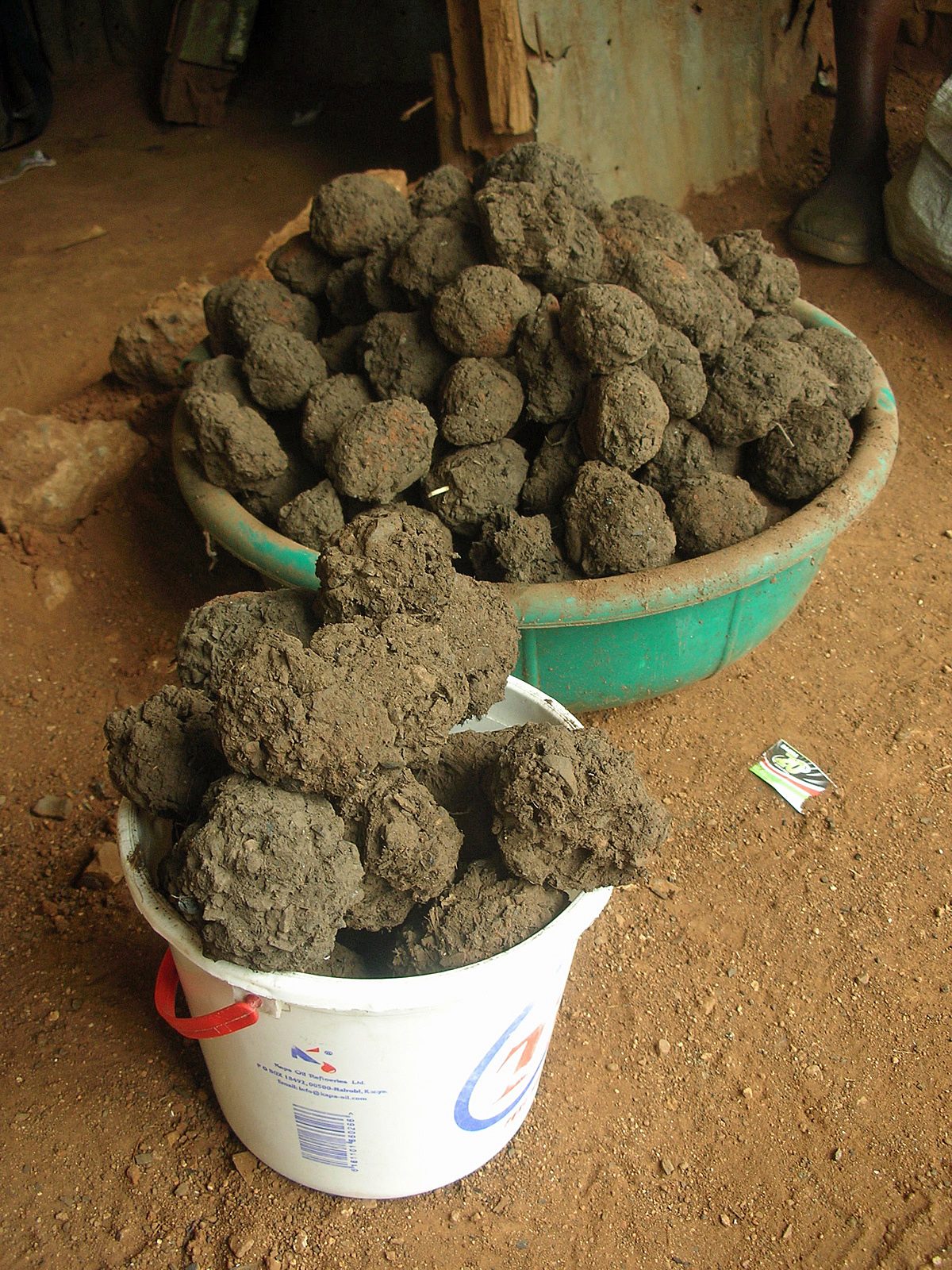 Hand-rolled fuel briquettes drying in basins in Uganda