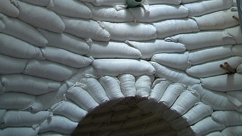 Interior of an earthbag structure showing tamped bag courses forming the walls and dome