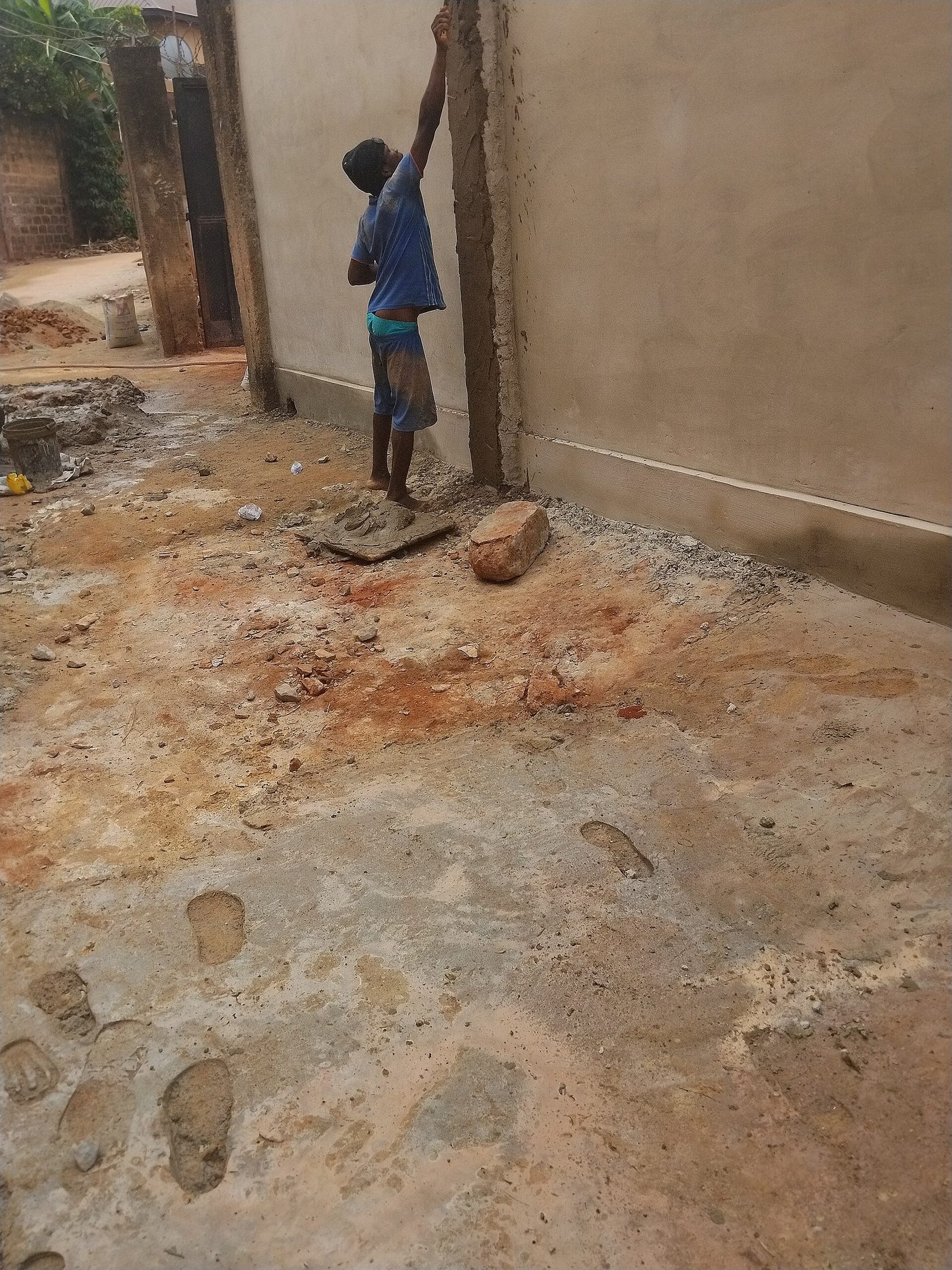 A plasterer working render onto a masonry wall with a hawk and trowel